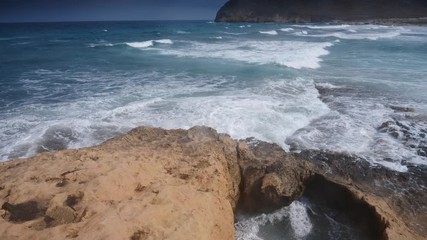 Wall Mural - Seascape. Beach El Playazo, Cabo de Gata, province AlmerĂ­a, Andalusia Spain. Rocky sea shore with waves splashing in slow motion. Tourist site