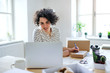 © HalfPoint/Westend61 - Smiling young woman preparing a package at desk