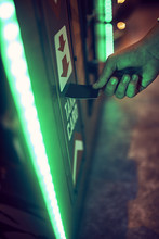 Close-up Of Teenage Boy Inserting Card Into Machine In An Amusement Arcade
