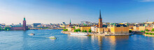 Aerial Scenic Panoramic View Of Stockholm Skyline With Old Town Gamla Stan, City Hall Stadshuset, Riddarholmen Island With Gothic Church Building And Boat Ship Sailing On Water Of Lake Malaren, Sweden