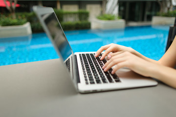 Wall Mural - close up woman fingers pressing keyboard on laptop sunny day swi