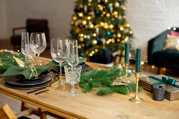 Table served for Christmas dinner in living room, close-up view, table setting, Christmas decoration.