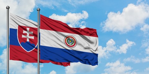 Slovakia and Paraguay flag waving in the wind against white cloudy blue sky together. Diplomacy concept, international relations.