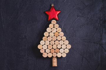 Christmas tree made of  wine corks on black background. Layout, flat lay, template. New Year winter holidays background