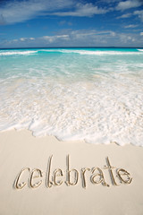 Wall Mural - celebrate message handwritten on a deserted tropical beach with blue waves crashing above smooth san