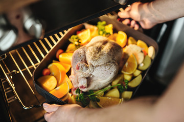 Wall Mural - Woman cooking raw chicken with vegetables