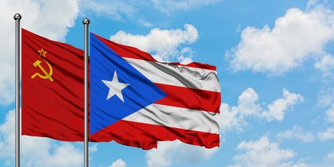 Soviet Union and Puerto Rico flag waving in the wind against white cloudy blue sky together. Diplomacy concept, international relations.