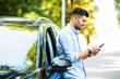 © F8  \ Suport Ukraine - Successful young man standing by his car texting on mobile phone