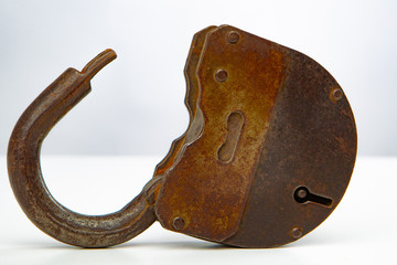Poster - Rusty lock on white background. The lock is open. An old padlock without a key lies on a white table. Decorative element. Vintage. Flea market.