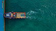 Aerial top down view of tug pilot boat assist vessel pushing large tanker to position, Keratsini, Attica, Greece