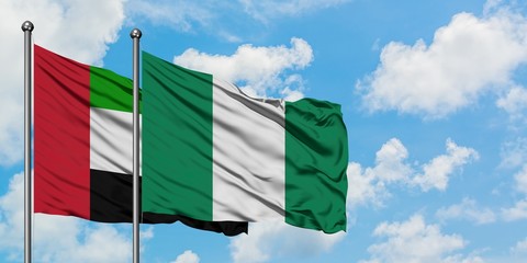 United Arab Emirates and Nigeria flag waving in the wind against white cloudy blue sky together. Diplomacy concept, international relations.