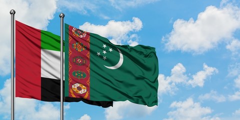 United Arab Emirates and Turkmenistan flag waving in the wind against white cloudy blue sky together. Diplomacy concept, international relations.