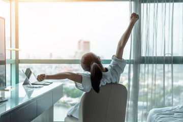 Poster - Work-life quality balance concept with happy city lifestyle Asian girl having a good day waking up from sleep in morning taking some rest, lazily relaxing in comfort in condominium or hotel bed room