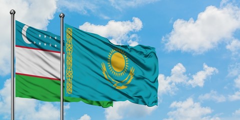 Uzbekistan and Kazakhstan flag waving in the wind against white cloudy blue sky together. Diplomacy concept, international relations.