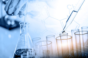 Wall Mural - hand of scientist holding flask with lab glassware and test tubes in chemical laboratory background,