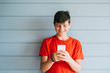 © Rafa Fernandez - Profile of a happy male teen texting on a smart phone