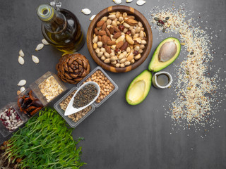 Wall Mural - Healthy fat sources and healthy food that is useful for heart - avocado, seeds, microgreens, nuts, beans, oatmeal ang oils. Diet and healthy lifestyle concept. Vegetarian