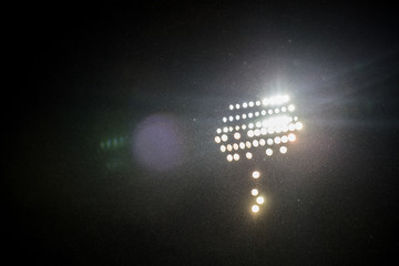 Wall Mural - spotlights in the stadium by dark with rain