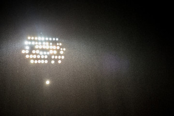 Wall Mural - spotlights in the stadium by dark with rain