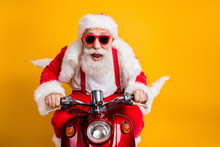 Fast X-mas Traveling. Crazy Funky Hipster Grey Haired Santa Claus In Red Hat Drive Scooter Hurry Scream Wear Shirt Suspenders Isolated Over Bright Color Background
