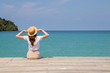 © allenkayaa - Young woman in a hat sits on a pier near the clear turquoise sea