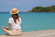 © allenkayaa - Young woman in a hat sits on a pier near the clear turquoise sea