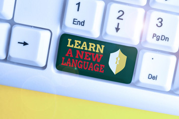 Poster - Text sign showing Learn A New Language. Business photo showcasing Study Words other than the Native Mother Tongue White pc keyboard with empty note paper above white background key copy space