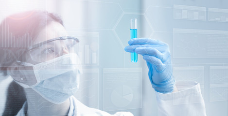 Wall Mural - woman chemist holding a test tube in light blue background