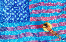 Woman Swimming In The Pool With USA Flag On Bottom