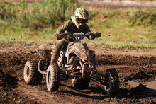 Motocross Quad Race With Races Who Are Covered With Mud In An Old Motocross Track. 