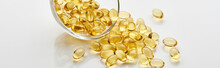 Golden Fish Oil Capsules In Glass Bowl On White Background, Panoramic Shot