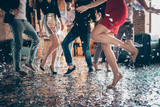 Cropped closeup photo of slim perfect legs girls guys meeting rejoicing dance floor x-mas party glitter flying wear formalwear red dress silver skirt pants restaurant indoors