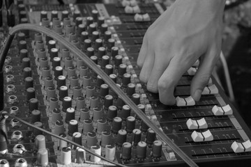 Fingers on music mixer, black and white