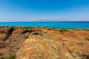 abandoned beach with rocks on coast, beautiful turquoise sea , deep blue sky with clouds and mountains on background, Mediterranean landscape