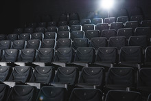 Cinema Hall With Rows Of Grey Seats In Darkness