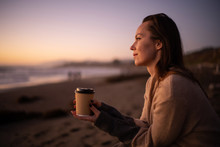 Woman Enjoying Hot Drink On A Sunset Near Ocean