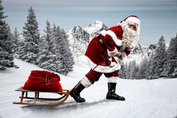 Wall Mural - Red Santa Claus riding a wooden sled. An older man with a beard delivers presents to a child. Winter mountains landscape and snow-covered trees with frost. Fir branches, winter time. Christmas spells