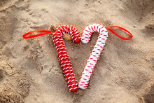 Red And White Candy Cane On Sandy Beach At Christmas Eve