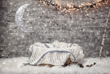 Basket For A Newborn Baby With A Blanket In A Christmas Studio Interior With A Garland, Moon And Snow 