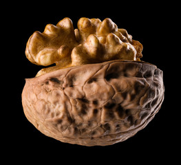 Wall Mural - Macro photo of half opened walnut with kernel isolated on a black background