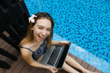 Wall Mural - portrait of top of happy female looking at camera with laptop on