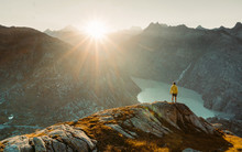  Man On Cracked Rocky Summit In Alps Watchin Amazing Sunset. Adventurous Man Standing On The Edge Of A Cliff Overlooking The Beautiful Swiss Rockies