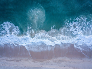 Drone picture of waves hitting the beach.