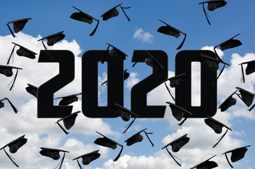 Wall Mural - airborne black graduation caps in summer sky for class of 2020