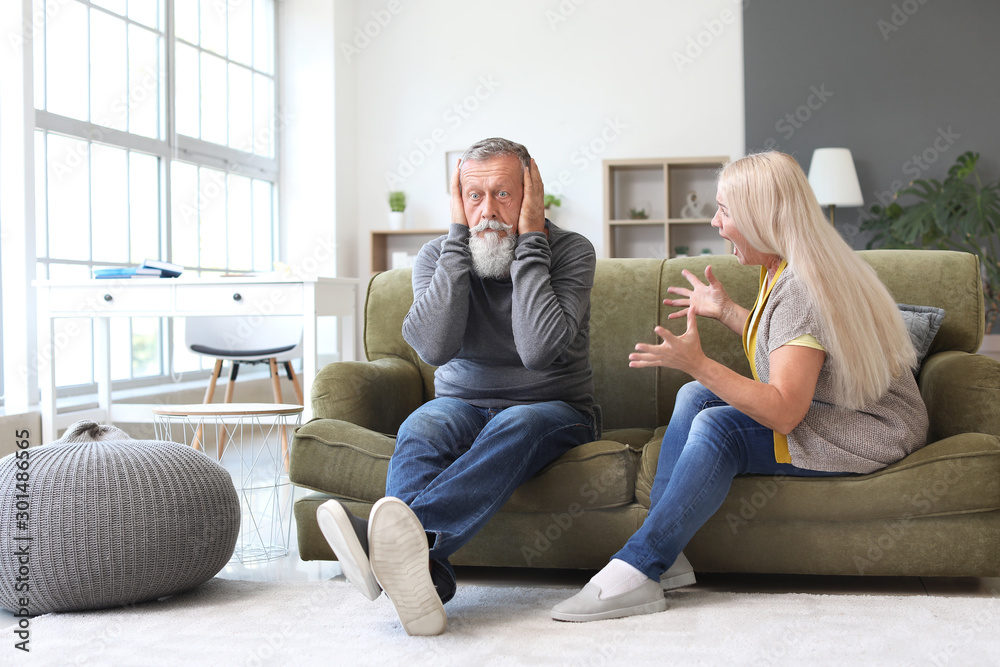 Angry mature couple having arguments at home
