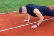 © 24K-Production - Young man doing push ups in the morning outdoor on the running race track