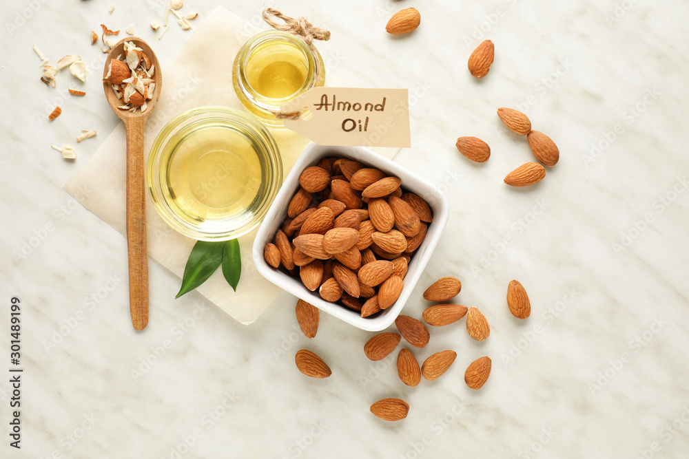 Tasty almond oil on white background