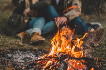 traveler couple camping in the forest and relaxing near campfire after a hard day. concept of trekki