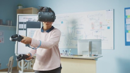 Fototapete - Elementary School Computer Science Class: Cute Girl Wearing Augmented Reality Headset and Using Controllers Learns Lessons in Virtual Reality Excited, Curious and Interested in Knowledge