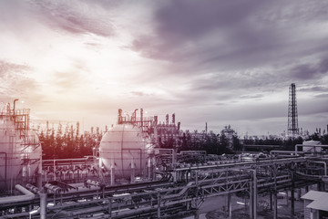 Gas storage sphere tanks and pipeline in oil and gas refinery industrial plant on sky sunset background